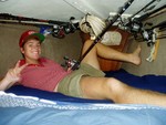 HT in the v-berth, where we sleep and dream about catching bigguns.  Cozy, ain�t it? (yes, we have about 10 rod and reels.) Behind HT is the chain locker; that�s part of the anchor rhode attached to the ceiling.  