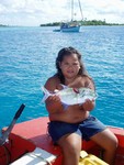 Rosette, age 6, Mana's youngest sister (yet the biggest!). Her mom says she's so big because her aunt overfeeds her when she goes off to school on the neighboring island. Most kids out here leave home to go to school much earlier than in Marquesas because there are such few towns. A motu in the distance.
